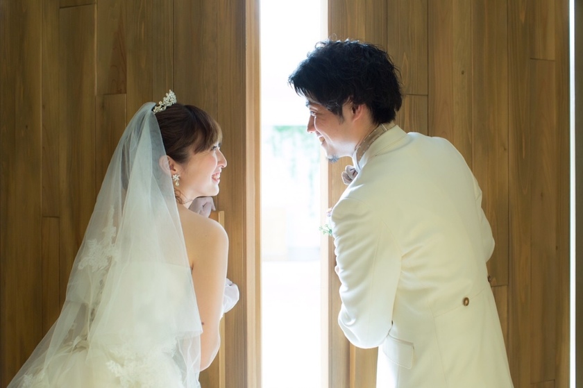 A Heart-Pounding Moment: The Adorable Snapshot of the Bride and Groom Peeking at Guests from Behind the Door!にて紹介している画像