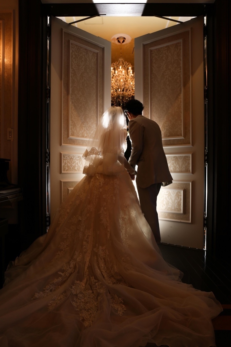 A Heart-Pounding Moment: The Adorable Snapshot of the Bride and Groom Peeking at Guests from Behind the Door!にて紹介している画像