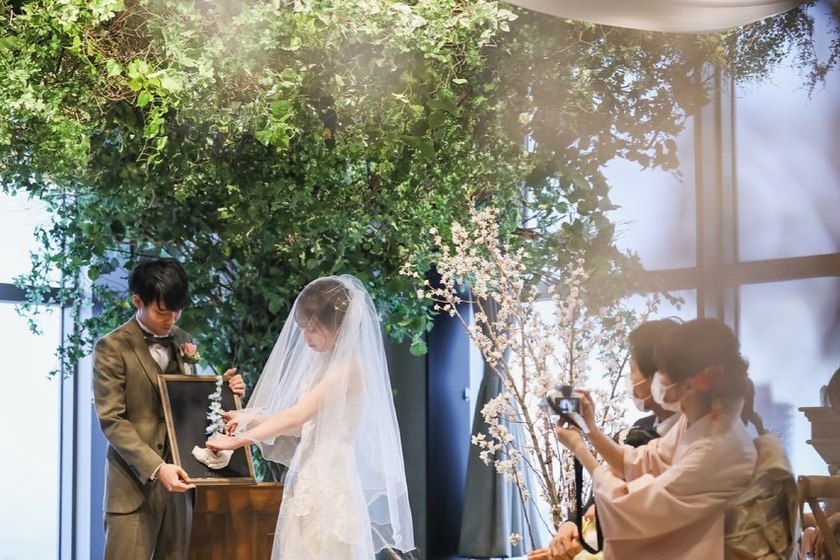 二人でお花を挿して完成。壁掛けタイプの一輪挿しを結婚証明書にするアイデアがおしゃれ🌷にて紹介している画像