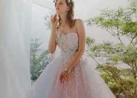 The wedding dresses by KIYOKO HATA are characterized by their transparency and romantic feminine colored dresses, embodying a limitless sense of romance.